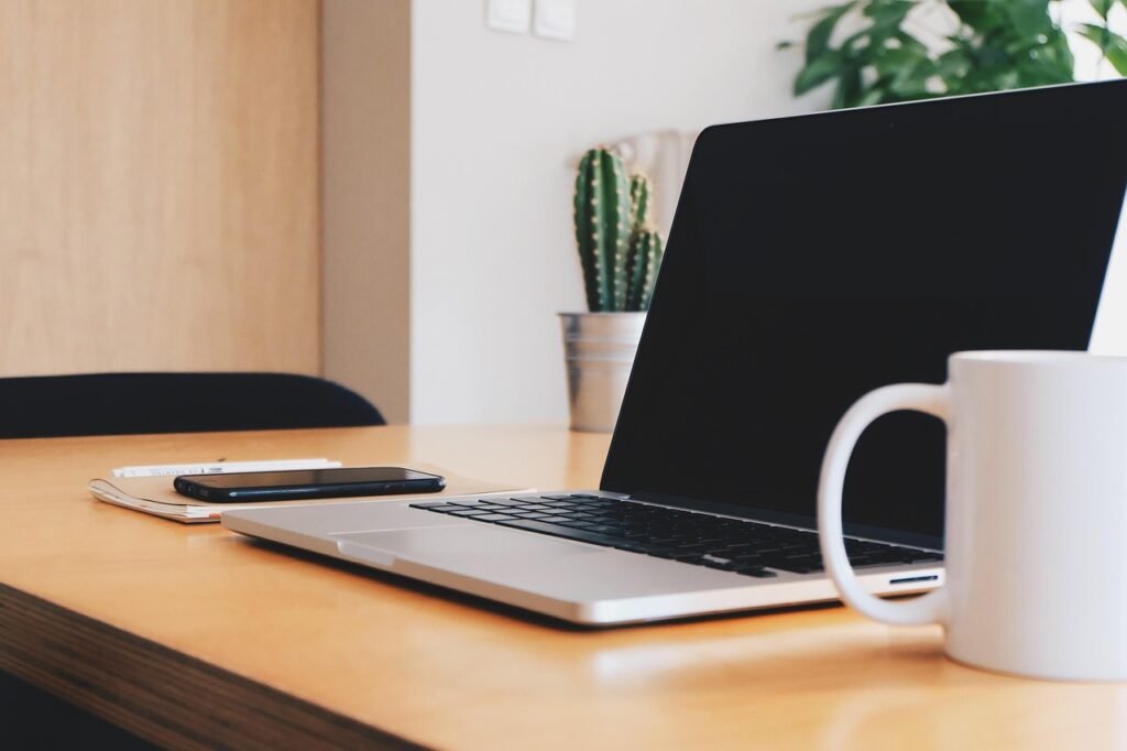 Bureau de travail avec ordinateur portable, tasse de café et téléphone